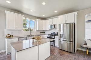 Kitchen featuring stainless steel appliances, white cabinets, recessed lighting, and dark wood-type flooring