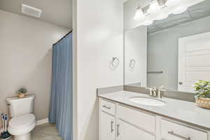 Full bathroom with vanity, light marble finish flooring, and curtained shower