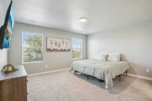 Bedroom with light carpet and a textured ceiling