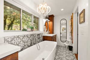 Primary Bathroom with Soaking Tub, Chandelier and Two Bath Vanities