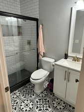 Bathroom with light tile patterned flooring, vanity, and a stall shower