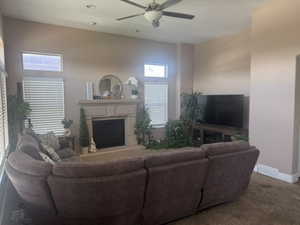 Living room featuring a fireplace with raised hearth, carpet floors, ceiling fan, and recessed lighting