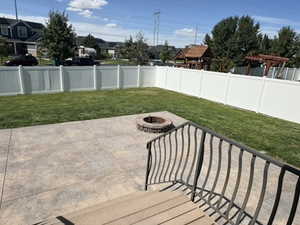 Fenced backyard featuring a patio and an outdoor fire pit