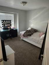 Bedroom featuring carpet and a desk