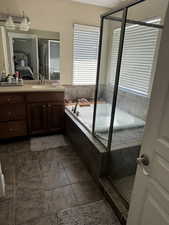 Full bath featuring vanity, a stall shower, a bath, and ensuite bath