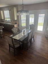 Dining area with dark wood finished floors and a chandelier
