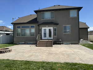 Rear view of property with a patio area, a fenced backyard, an outdoor fire pit, and stucco siding