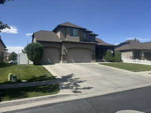 View of front of home with concrete driveway, stucco siding, stone siding, and a garage