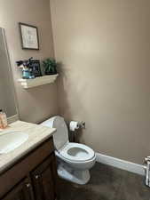Half bath featuring vanity and dark tile patterned floors
