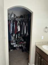 Walk in closet with carpet flooring and a sink