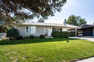 Ranch-style home featuring a front lawn