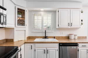 Kitchen featuring appliances with stainless steel finishes and white cabinets