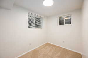 Carpeted spare room with baseboards