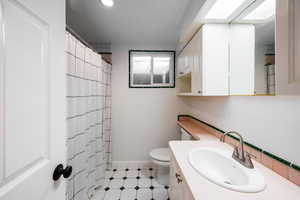 Bathroom with vanity, a shower with shower curtain, and recessed lighting