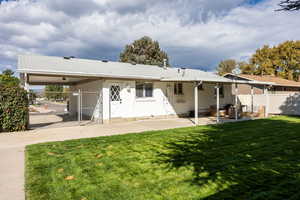 Rear view of house with a gate, a patio area, and an attached carport