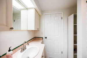 Bathroom featuring vanity, a skylight, and tile patterned floors