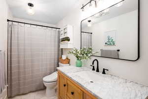 Bathroom featuring vanity, light tile patterned floors, and a shower with curtain