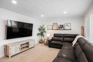Living area featuring light carpet, recessed lighting, and ornamental molding