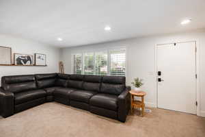 Living room featuring light carpet, ornamental molding, and recessed lighting