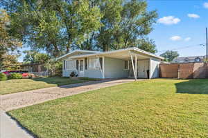 View of front of house with driveway and a carport. Carport can fit one car, and the entire driveway can fit a total of 3 cars