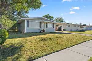 View of front of house with driveway and a carport. Carport can fit one car, and the entire driveway can fit a total of 3 cars