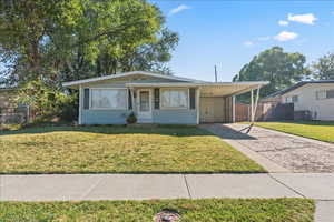 View of front of house with driveway and a carport. Carport can fit one car, and the entire driveway can fit a total of 3 cars