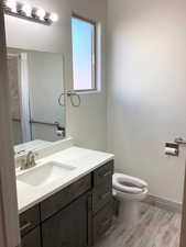 Full primary bath featuring light wood-style floors, vanity, and a shower with curtain