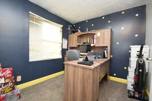 Home office featuring dark colored carpet