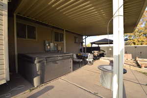 View of patio featuring a hot tub and a gazebo