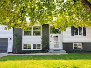Bi-level home with a front yard and brick siding