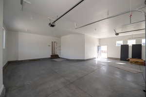 Garage with baseboards and a garage door opener