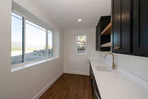 Kitchenette featuring open shelves, quartz counters, dark cabinetry, and recessed lighting