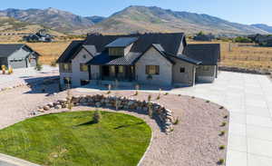 View of front of home with a standing seam roof, a metal roof, stone siding, covered porch, and a mountain view