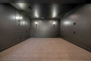 Carpeted cinema room with a decorative wall and a textured ceiling