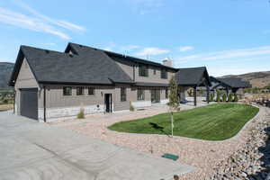 View of front of property with board and batten siding, roof with shingles, a garage, and a mountain view