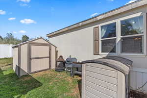 View of home's exterior with a storage unit and a lawn