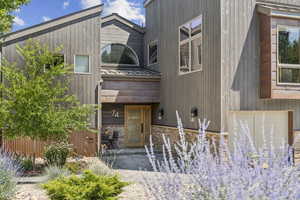 View of front facade with a metal roof, stone siding, and a standing seam roof