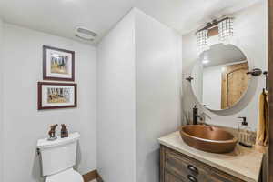 Half bathroom with vanity and toilet