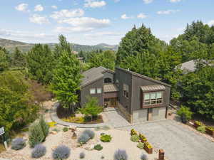 View of front facade featuring a metal roof, a standing seam roof, decorative driveway, and stone siding