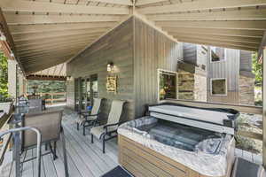 Wooden terrace featuring a hot tub