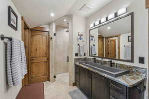 Full bathroom featuring a stall shower, vanity, a textured ceiling, and recessed lighting