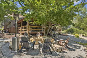 View of yard with a patio area, a fire pit, stairs, and a deck