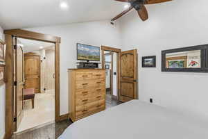 Bedroom with vaulted ceiling, dark wood finished floors, a ceiling fan, and recessed lighting