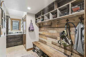 Mudroom with recessed lighting, wood walls, and a textured ceiling