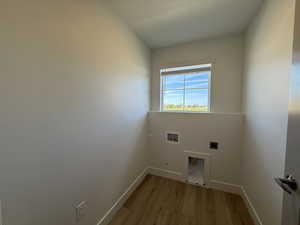 Washroom featuring light wood-style flooring, hookup for a washing machine, and hookup for an electric dryer