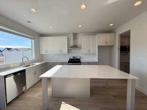 Kitchen with a kitchen island, backsplash, recessed lighting, light stone countertops, and wall chimney exhaust hood