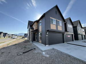 View of home's exterior with a residential view, concrete driveway, and a garage