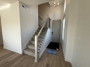 Stairs featuring wood finished floors and a high ceiling