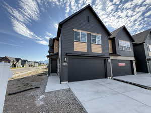 Contemporary home featuring a residential view, a garage, and driveway