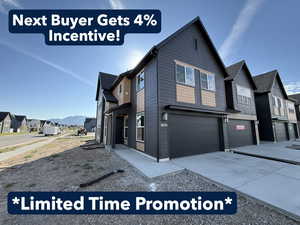 View of home's exterior with a residential view, concrete driveway, and an attached garage